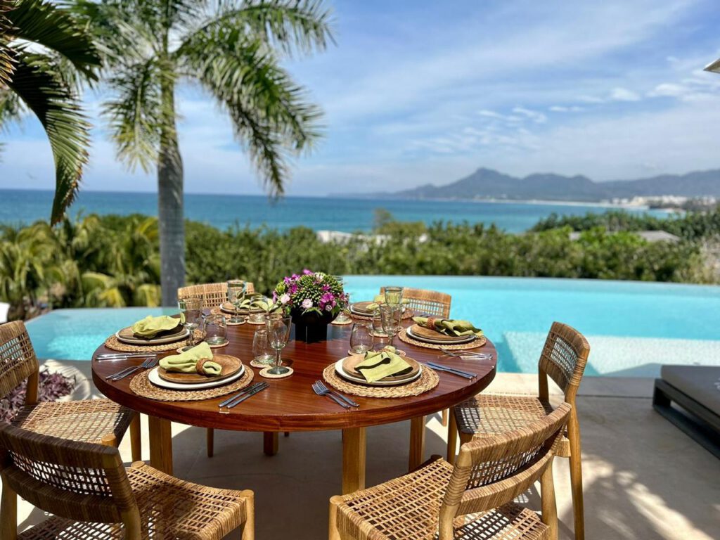 Elegant outdoor dining table set by the pool at Casa Roka luxury beachfront villa in Punta Mita
